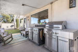 View of patio featuring sink, an outdoor kitchen, and a grill