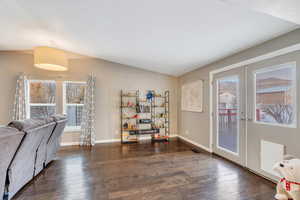 Living area featuring dark hardwood / wood-style flooring, french doors, and a textured ceiling