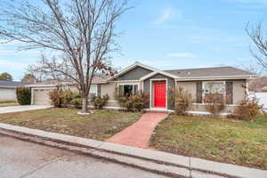 Single story home featuring a garage and a front yard