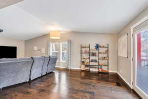 Living room featuring dark hardwood / wood-style floors and vaulted ceiling