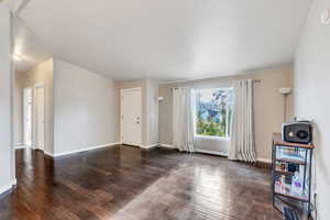 Unfurnished room featuring dark hardwood / wood-style floors and a textured ceiling