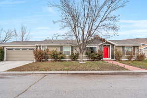 Ranch-style house with a garage and a front lawn