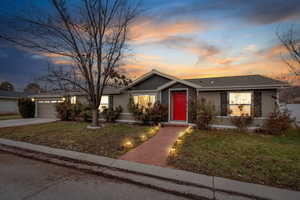 Single story home featuring a lawn and a garage