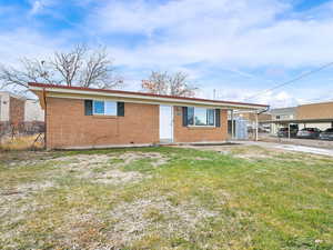 View of front of house with a carport and a front yard