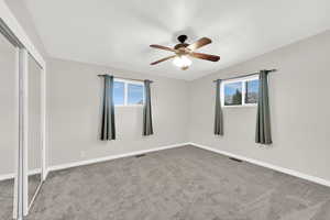 Unfurnished bedroom featuring carpet flooring, ceiling fan, and a closet