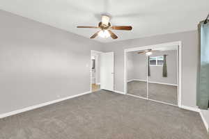 Unfurnished bedroom with ceiling fan, a closet, and carpet