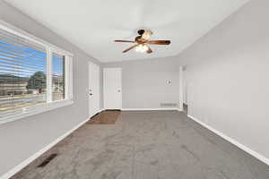 Carpeted empty room with ceiling fan