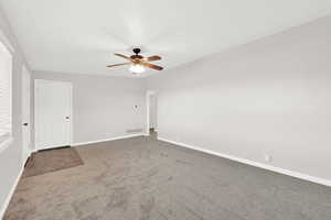 Unfurnished living room featuring carpet flooring and ceiling fan