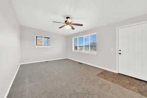 Unfurnished living room with carpet flooring, ceiling fan, and lofted ceiling