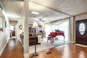 Foyer entrance with a textured ceiling, hardwood / wood-style flooring, and ceiling fan