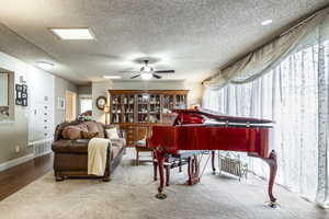 Miscellaneous room featuring ceiling fan, carpet floors, and a textured ceiling