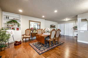 Dining room with hardwood / wood-style flooring, built in features, and a textured ceiling