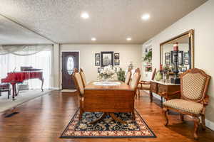 Dining space with built in features, hardwood / wood-style floors, and a textured ceiling