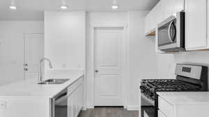 Kitchen featuring sink, white cabinets, light hardwood / wood-style flooring, and appliances with stainless steel finishes