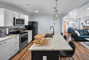 Kitchen with a breakfast bar island with sink, and appliances with stainless steel finishes