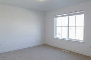 Empty room with light colored carpet