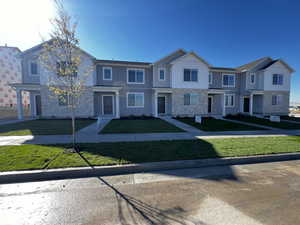 Townhome / multi-family property featuring a front yard