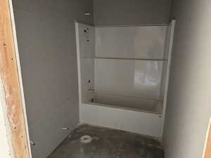 Bathroom with concrete flooring and a bathtub