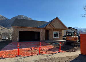 View of front of property featuring a garage and a mountain view