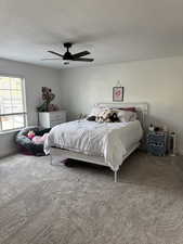 Carpeted bedroom with ceiling fan and a textured ceiling