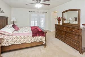 Carpeted bedroom featuring ceiling fan