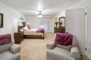 Bedroom with ceiling fan and light carpet