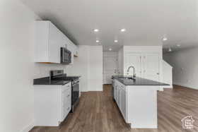 Kitchen featuring white cabinetry, sink, and stainless steel stove