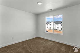 Unfurnished room with dark carpet