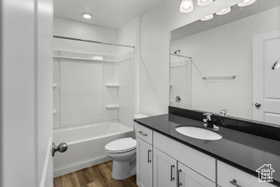 Full bathroom with shower / bath combination, vanity, toilet, and wood-type flooring