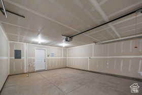 Garage featuring a garage door opener and electric panel