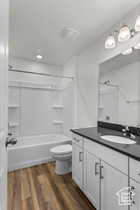 Full bathroom featuring toilet, hardwood / wood-style floors, vanity, and washtub / shower combination