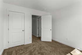 Unfurnished bedroom with a closet and dark colored carpet