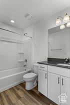 Full bathroom featuring vanity, shower / bath combination, toilet, and hardwood / wood-style flooring