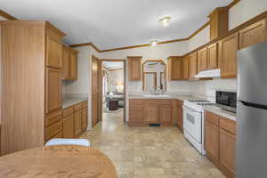 Kitchen with stainless steel appliances, vaulted ceiling, crown molding, and sink