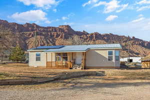 View of front of home featuring a mountain view, covered porch, and solar panels