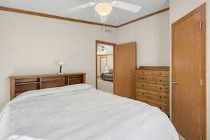 Bedroom with light colored carpet, ceiling fan, and ornamental molding