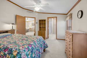 Carpeted bedroom with ceiling fan, crown molding, and lofted ceiling