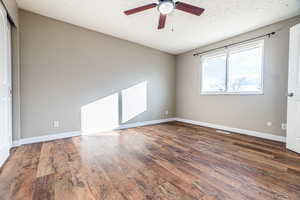 Spare room featuring ceiling fan, dark hardwood / wood-style flooring, and a textured ceiling