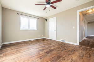 Spare room featuring a textured ceiling, dark hardwood / wood-style floors, and ceiling fan