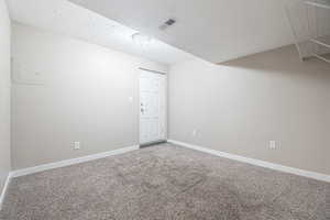 Empty room featuring carpet flooring and a textured ceiling