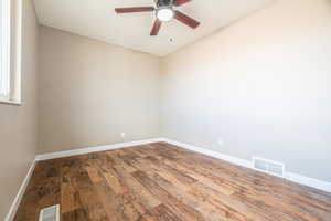 Spare room with hardwood / wood-style floors and ceiling fan