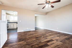 Unfurnished room featuring ceiling fan, sink, dark wood-type flooring, and a textured ceiling