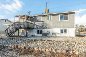 Back of property with cooling unit and a patio