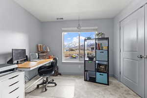 Carpeted home office featuring a mountain view and a healthy amount of sunlight