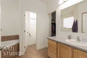 Bathroom featuring a bathing tub, tile patterned flooring, and vanity