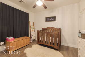 Bedroom featuring ceiling fan and dark hardwood / wood-style flooring