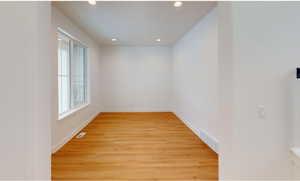 Spare room with light wood-type flooring, baseboards, visible vents, and recessed lighting