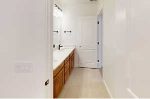 Full bathroom featuring double vanity, baseboards, visible vents, tile patterned flooring, and a sink