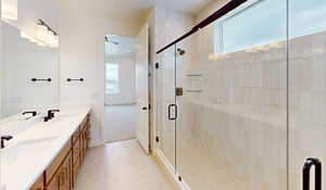 Bathroom with double vanity, tile patterned flooring, a sink, and a shower stall