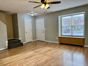 Interior space featuring ceiling fan, a textured ceiling, and light wood-type flooring